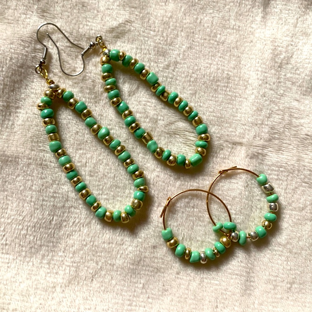This is two sets of earrings with teal and gold beads